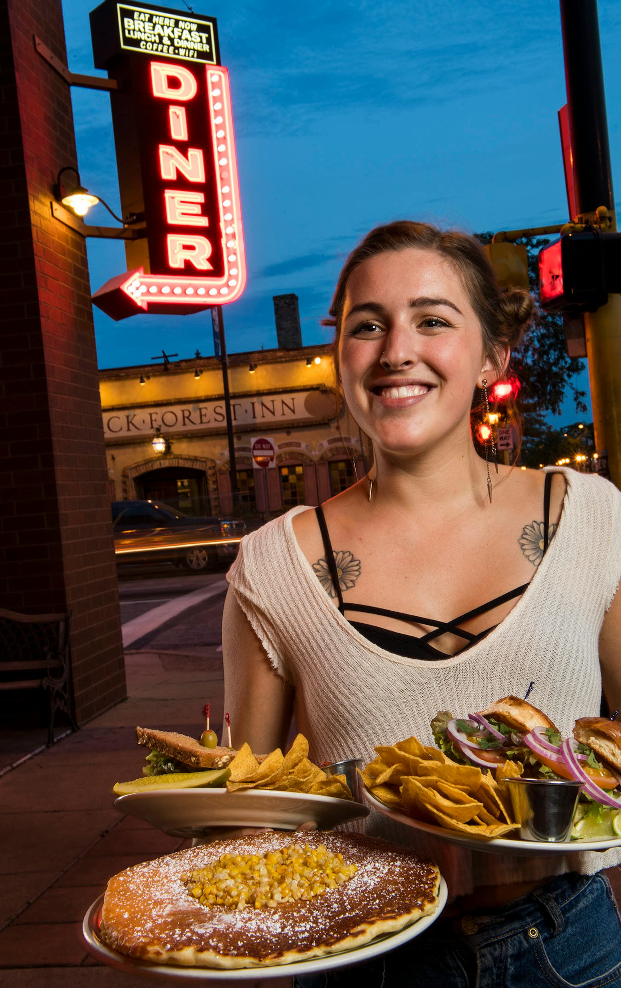 Alex Fitzgerald stood with plates in front of The Bad Waitress in Minneapolis.