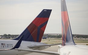 In this Thursday, Nov. 29, 2018 photo, the tails of two Delta Air Lines planes are shown parked at the gates at Fort Lauderdale–Hollywood Inter