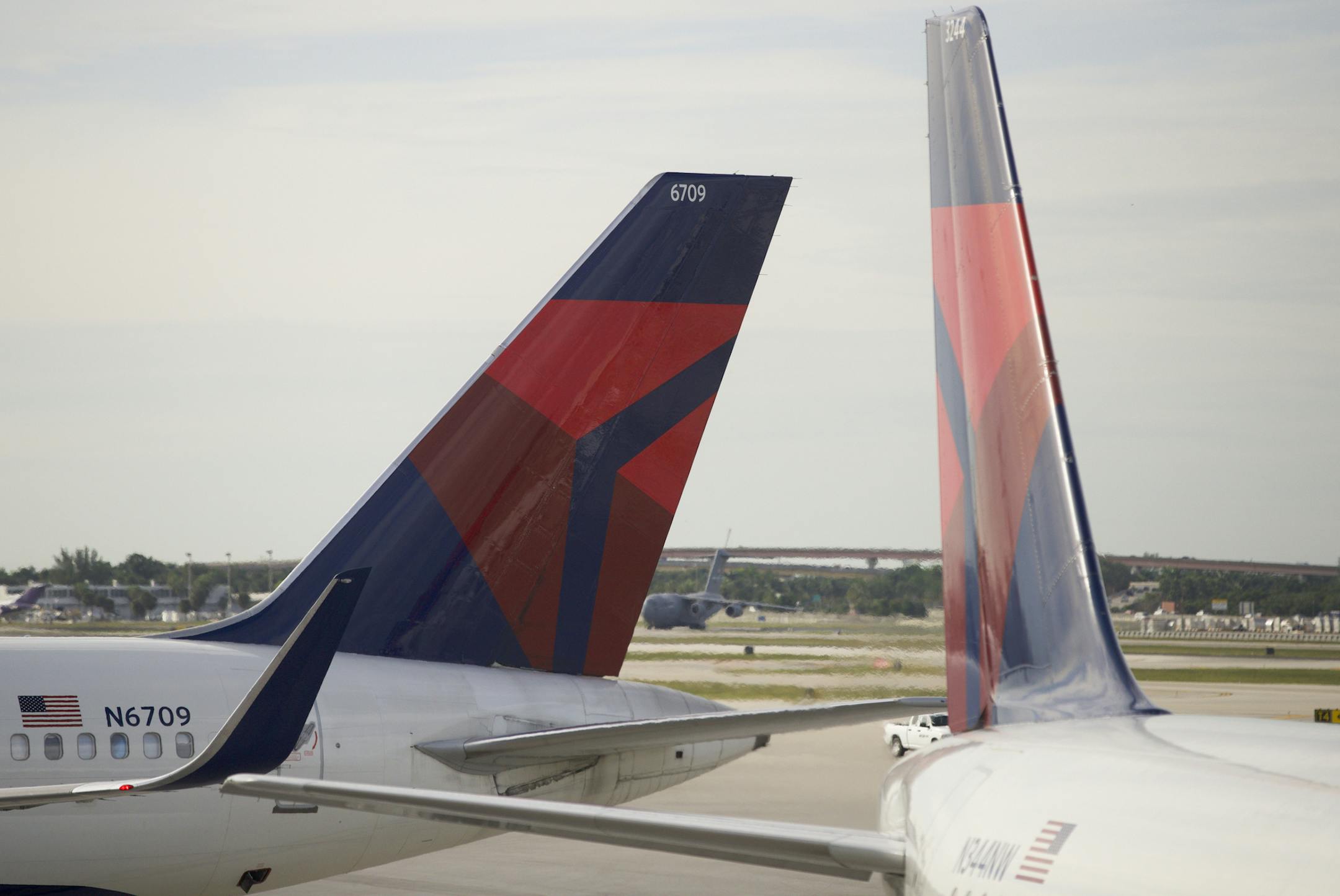 In this Thursday, Nov. 29, 2018 photo, the tails of two Delta Air Lines planes are shown parked at the gates at Fort Lauderdale&#x2013;Hollywood International Airport in Fort Lauderdale, Fla. (AP Photo/Wilfredo Lee)