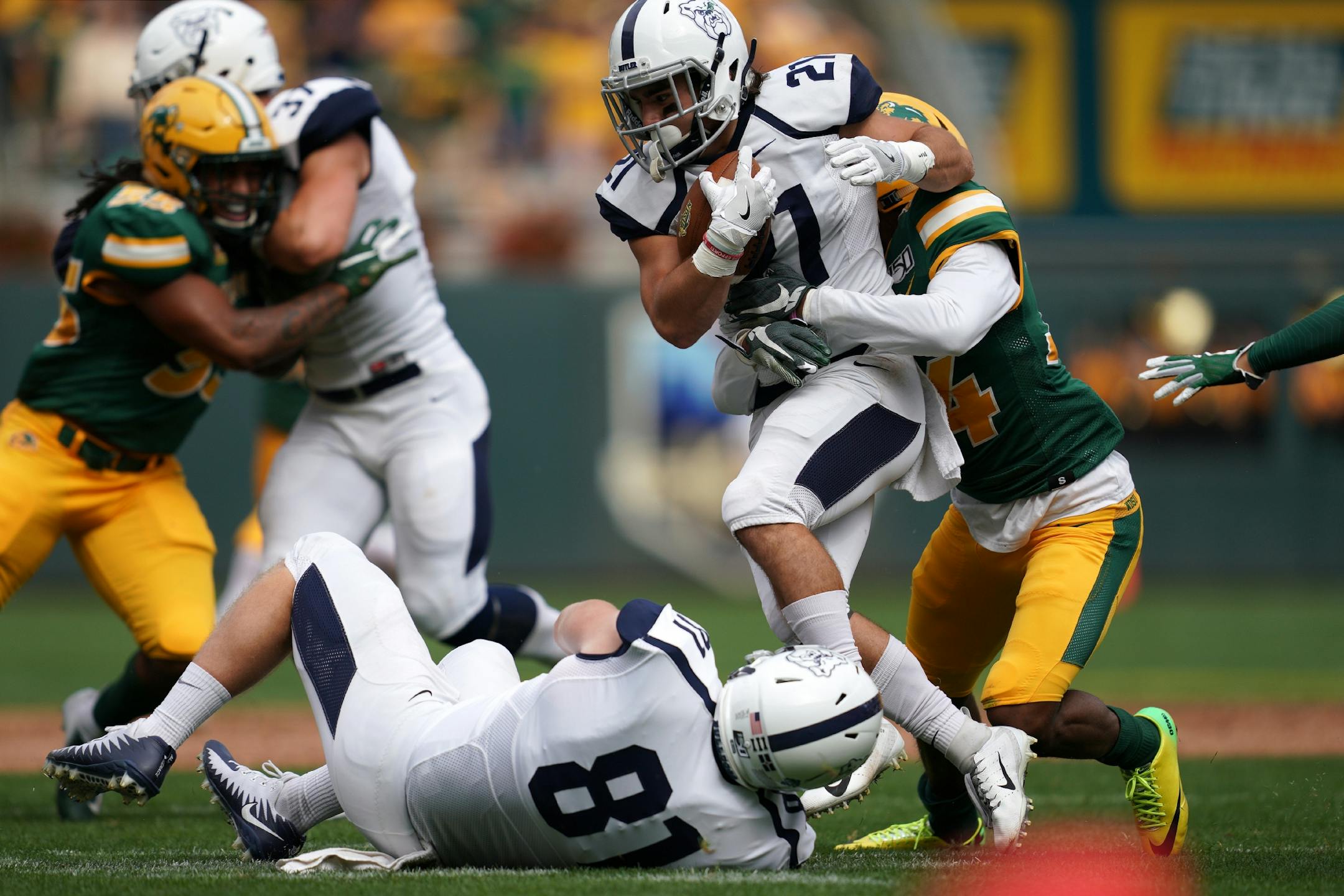 Butler Bulldogs running back AJ Deinhart (21) was brought down by North Dakota State Bison cornerback Josh Hayes (14) as he ran the ball in the first half.