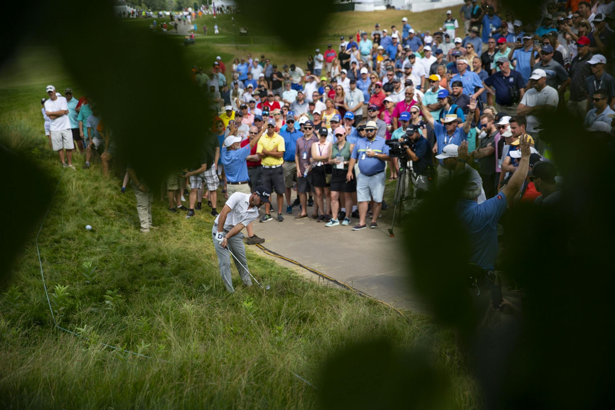 Brian Harman hits a ball out of the tall grass close to the cart path on the eighteenth hole. ALEX KORMANN ¥ alex.kormann@startribune.com Competitors for the 3M Open took to the course on Saturday.