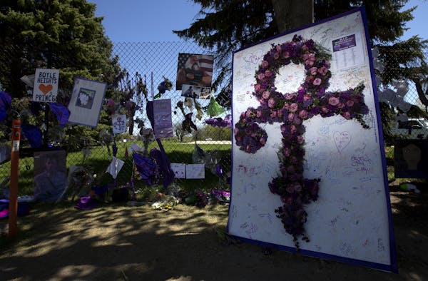 Balloons, flowers and other mementos were attached to the fence and trees surrounding Paisley Park in Chanhassen in honor of the memory of Prince.
