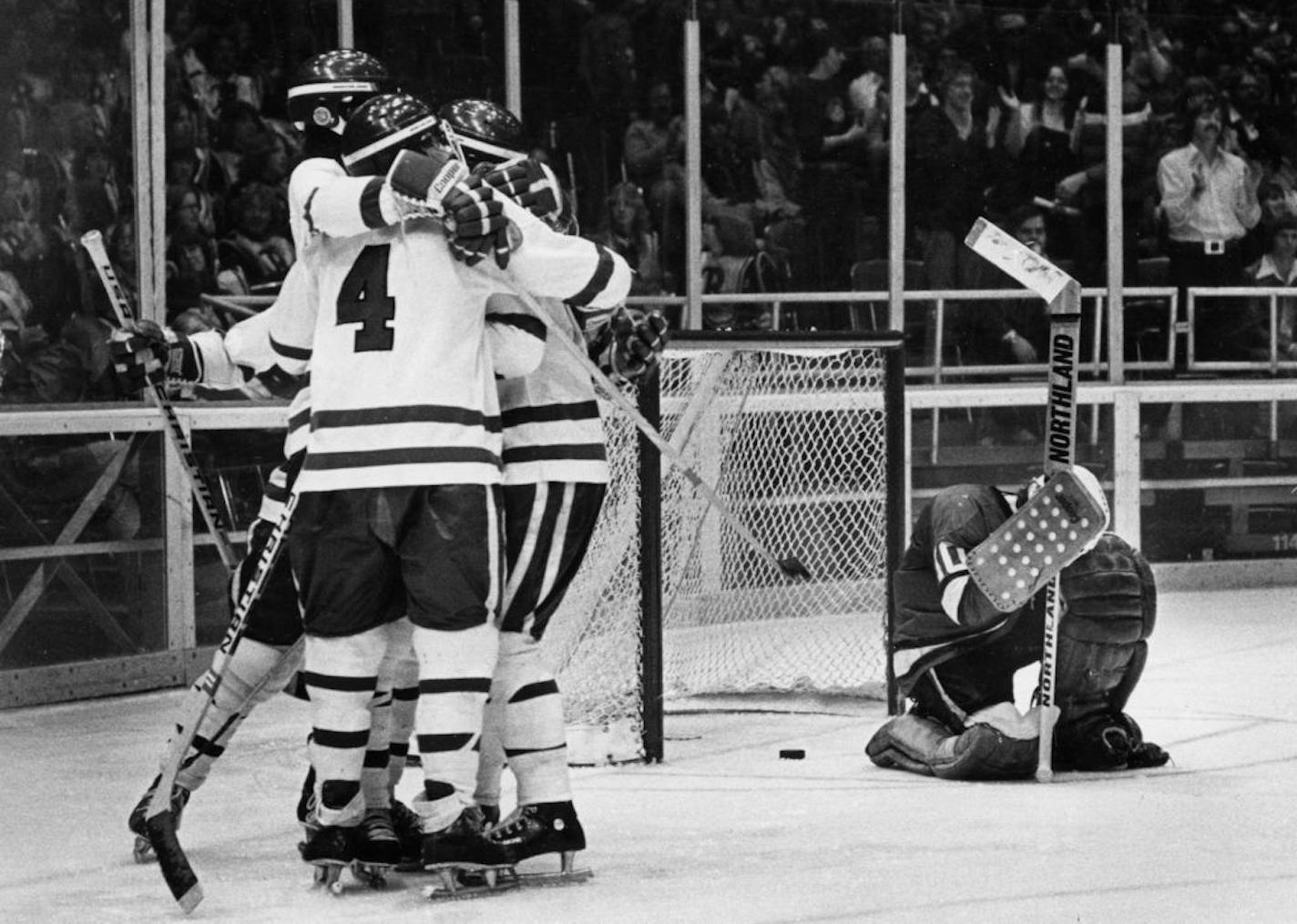 Minnesota high school state hockey tournament, 1978. -- Brian Vatnsdal (4) hugged Neal and Aaron Broten and Butzy Erickson as winning Roseau goal laid behind John Marshall goalie Paul Butters.