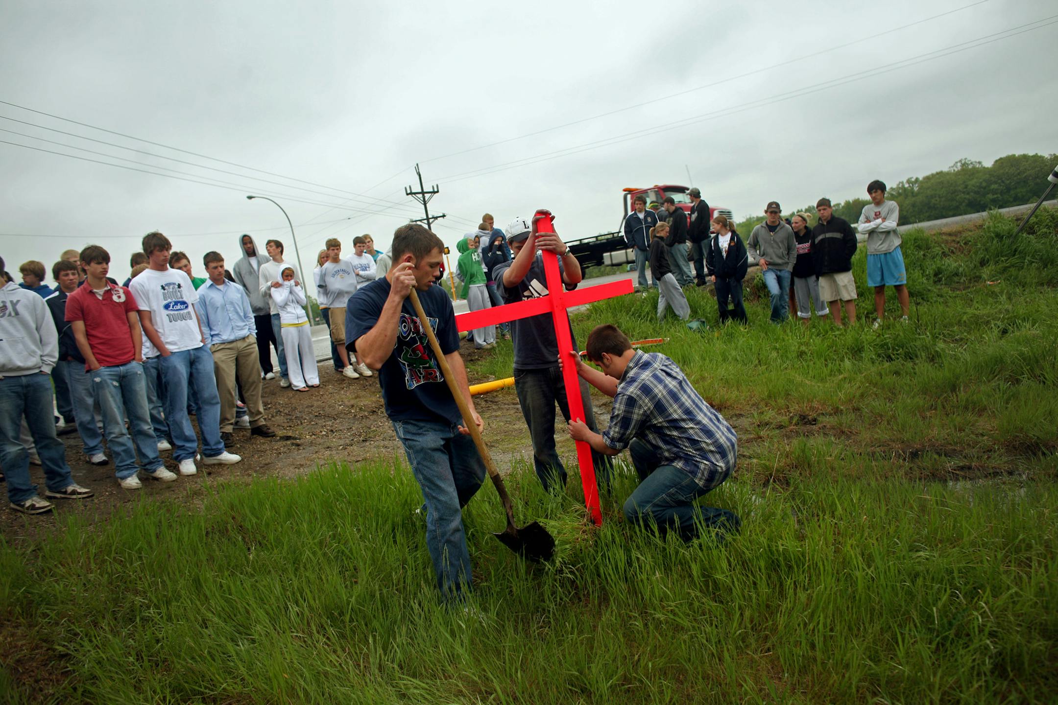 Jacob Young, Nicholas Zelmer and Michael Sawatzke erected the cross they made Thursday morning. Fellow students spent much of the day writing sympathy cards and trying to absorb the news.