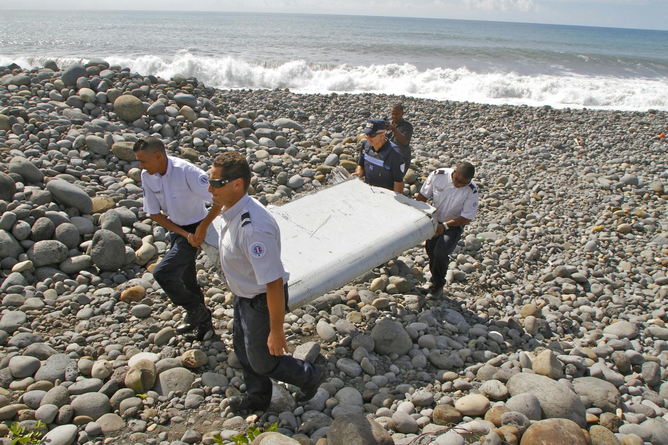 In this July 29, 2015 file photo, French police officers carry a piece of debris from a plane in Saint-Andre, Reunion Island. If a wing fragment found in the western Indian Ocean turns out to be part of missing Flight 370, experts say, there are probably other pieces of the aircraft that floated off rather than sinking to the bottom of the ocean. Finding them remains the hard part. John Page, an aircraft design expert at the University of New South Wales in Australia, said the discovery of the f