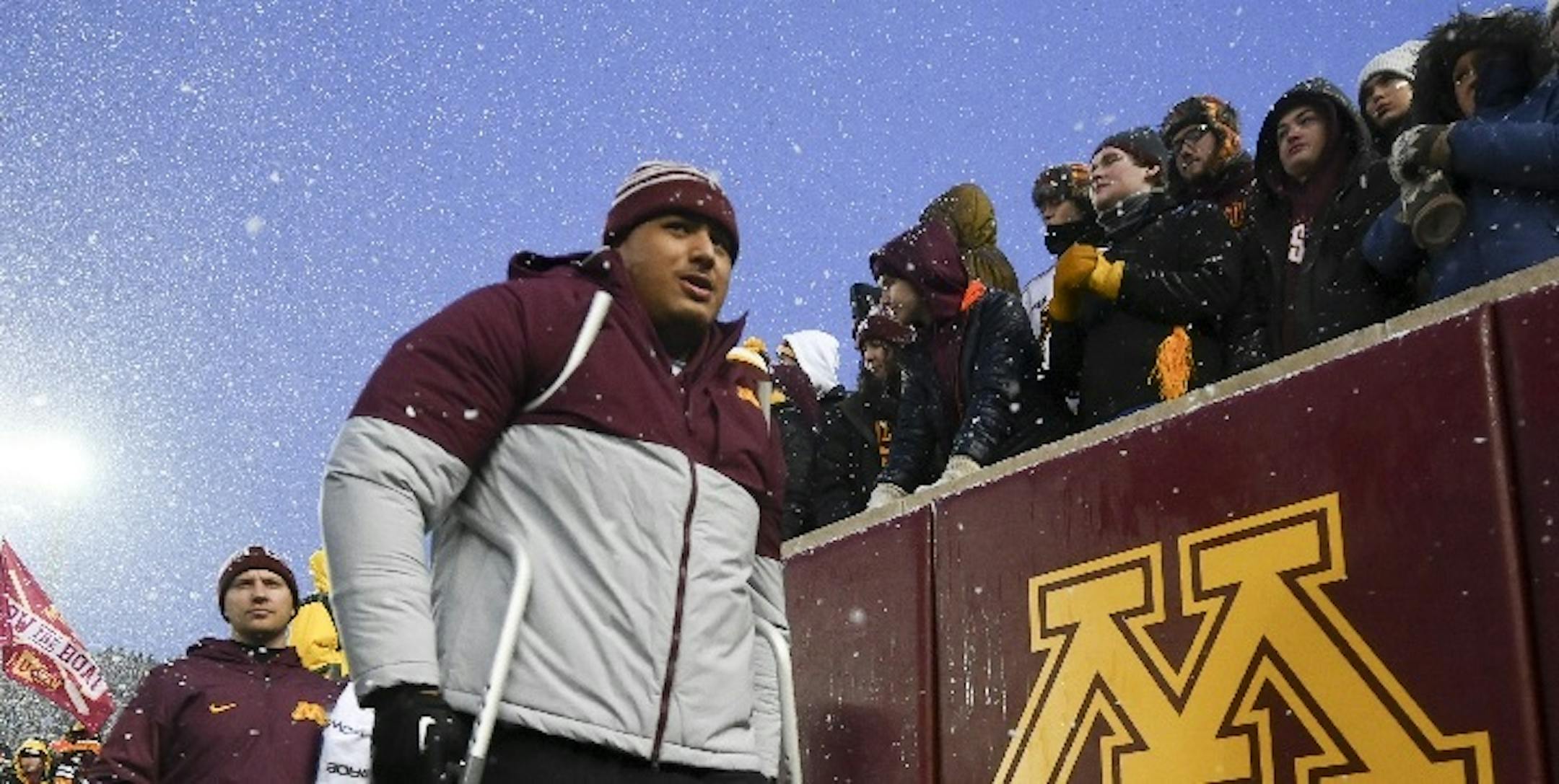 Offensive tackle Daniel Faalele (shown on crutches at the Nov. 30 Wisconsin game) sat out the Outback Bowl, wearing a brace on his lower left leg.
