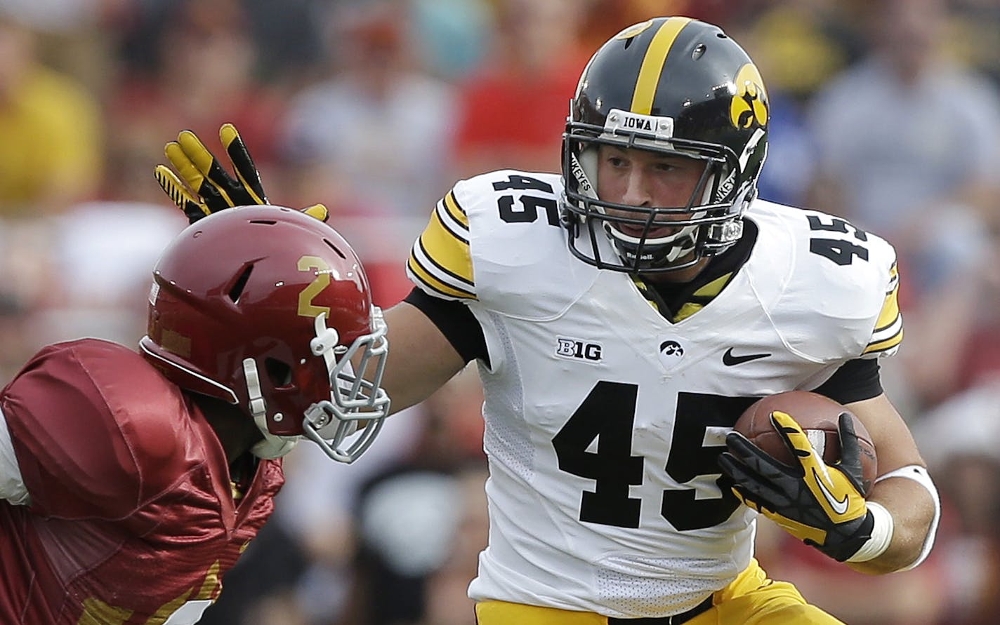 Iowa fullback Mark Weisman, right, runs from Iowa State defensive back Jansen Watson, left, during the first half of an NCAA college football game, Saturday, Sept. 14, 2013, in Ames, Iowa. (AP Photo/Charlie Neibergall)