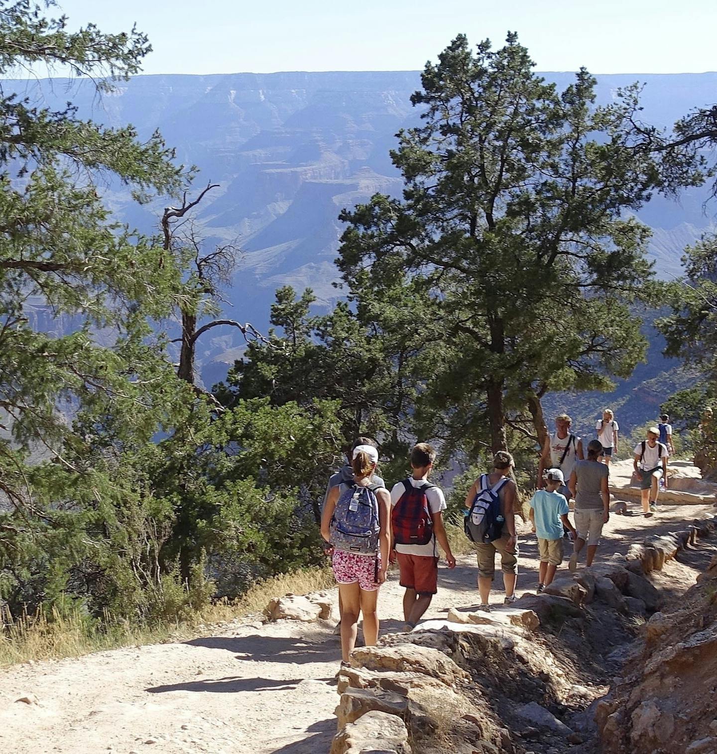 FILE - In this July 27, 2015, file photo, hikers cross paths along Bright Angel Trail heading into and out of the Grand Canyon at Grand Canyon National Park, Ariz. Zika fears are leading some to book away from the Caribbean and Florida. The American Southwest, New England and Bermuda are providing a virus-free alternative, but destinations are hesitant to market themselves as such. (AP Photo/Ross D. Franklin, File)