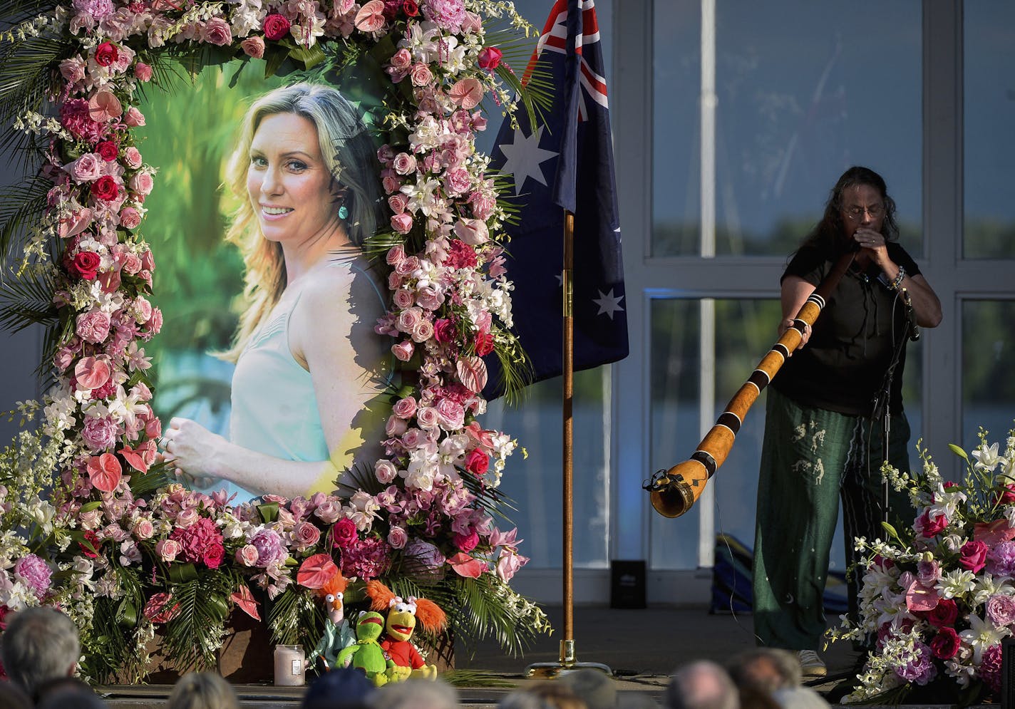 FILE - In this Aug. 11, 2017, file photo, Johanna Morrow plays the didgeridoo during a memorial service for Justine Damond in Minneapolis. Hennepin County Attorney Mike Freeman has convened a grand jury in the July 2017 police shooting of Damond by Minneapolis Officer Mohamed Noor. Freeman said previously he would no longer use grand juries in police shootings, and would decide those cases himself. (Aaron Lavinsky/Star Tribune via AP, File)