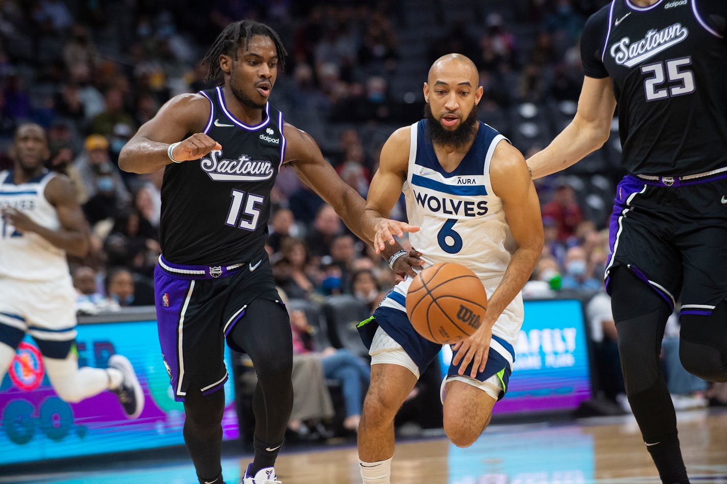 Sacramento Kings Davion Mitchell (15) guards Minnesota Timberwolves guard Jordan McLaughlin (6) during the first quarter of an NBA basketball game in Sacramento, Calif., Tuesday, Feb. 8, 2022. (AP Photo/Randall Benton)