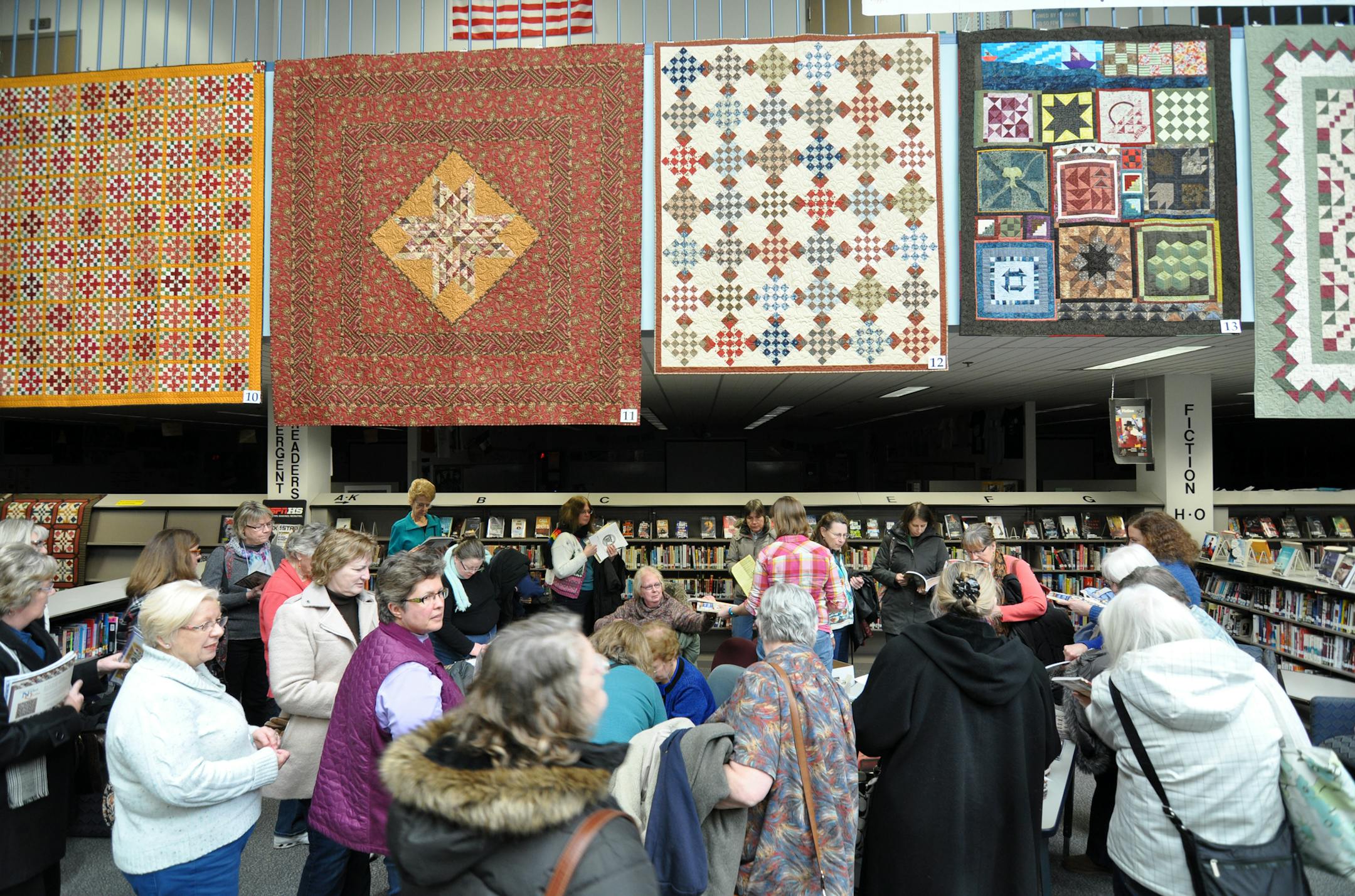 Photo by LIz Rolfsmeier A group of quilters surrounds a booth at the opening day of ìQuilt Connections,î Eagan High Schoolís 19th annual quilt exhibit honoring Women's History Month.