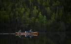 Tony Jones, his dog Crosby, and Bob Timmons paddled from Mountain Lake toward their portages to Moose Lake Friday. ] Aaron Lavinsky ¥ aaron.lavinsky@