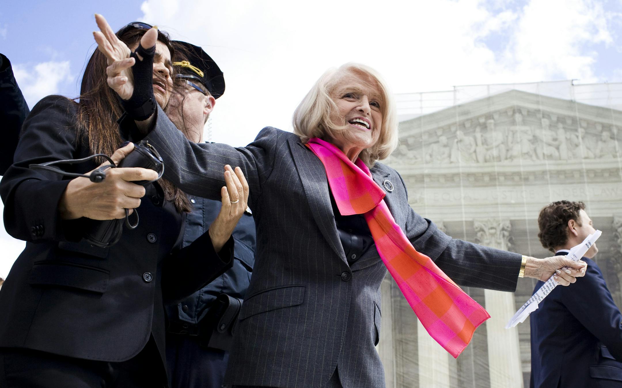 Edith Windsor waves to supporters outside the U.S. Supreme Court in Washington, March 27, 2013. A majority of the justices on Wednesday questioned the constitutionality of the Defense of Marriage Act of 1996, as the court took up the volatile issue of same-sex marriage for a second day. (Christopher Gregory/The New York Times)