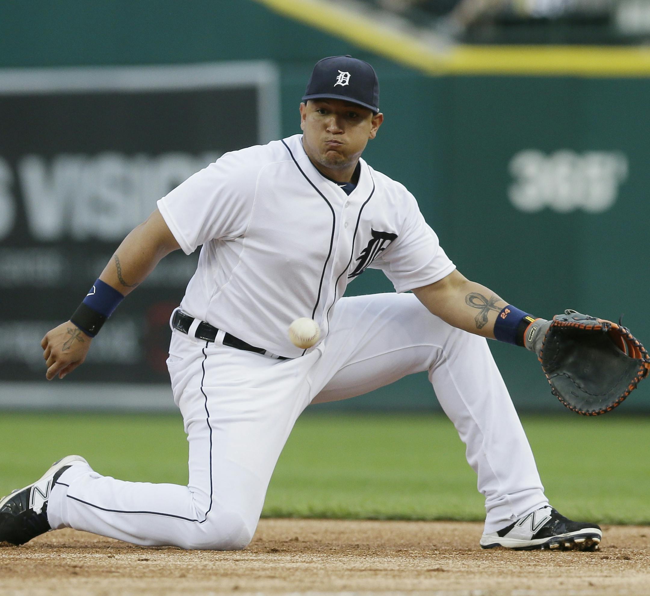 Detroit Tigers first baseman Miguel Cabrera snags a grounder hit by Cincinnati Reds' Brennan Boesch during the third inning of a baseball game, Monday, June 15, 2015, in Detroit. Boesch was out at first. (AP Photo/Carlos Osorio)