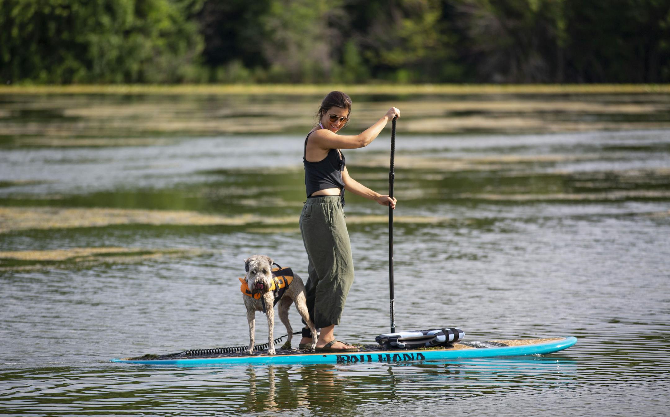 Liz Herrity and her dog, Opalina, paddle board down Lake of the Isles on Sunday. ALEX KORMANN ¥ alex.kormann@startribune.com The temperature climbed into the mid-90s on Sunday July 14, 2019. Minnesotans found anyway they could to stay cool.