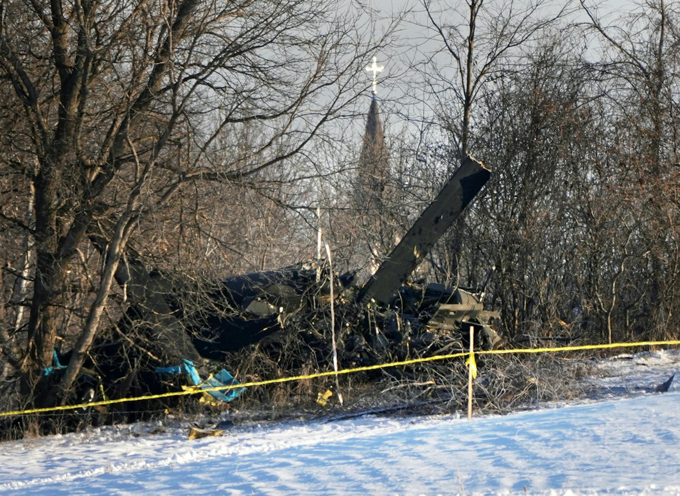The steeple of Holy Cross Catholic Church in Marty rises in the distance Friday over the crash site of a Minnesota National Guard Black Hawk helicopter that killed three service members Thursday afternoon.