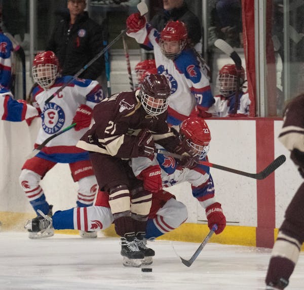 South St. Paul Packers forward Alyiah Danielson (21) earned a tripping penalty for a hit on Simley Spartans defenseman Courtney Kurowski (22) in the f