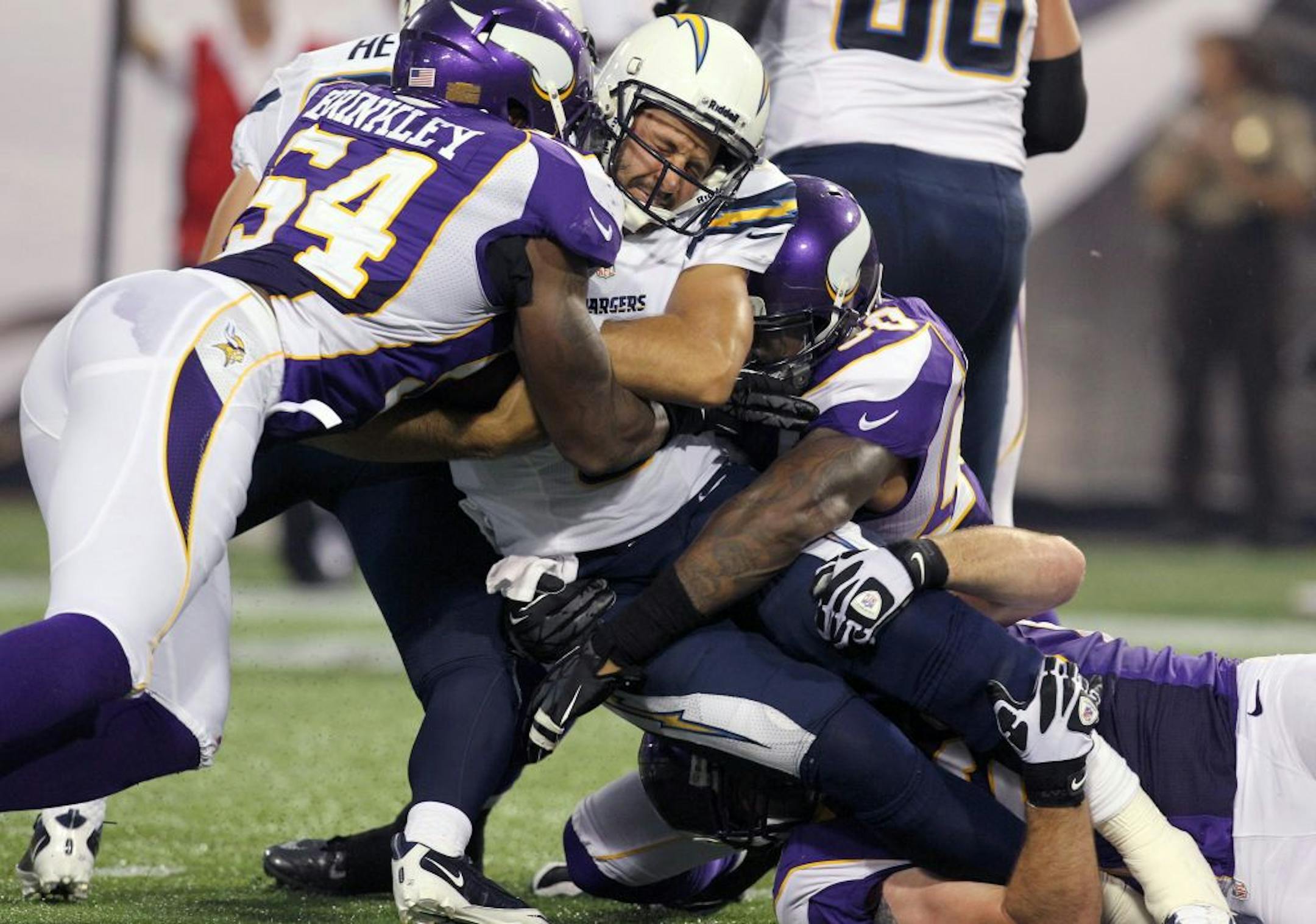 San Diego Chargers quarterback Charlie Whitehurst, center, is sacked by Minnesota Vikings linebacker Jasper Brinkley (54), linebacker Erin Henderson (50) and defensive end Jared Allen, bottom right, in the first half of an NFL preseason football game on Friday, Aug. 24, 2012, in Minneapolis.