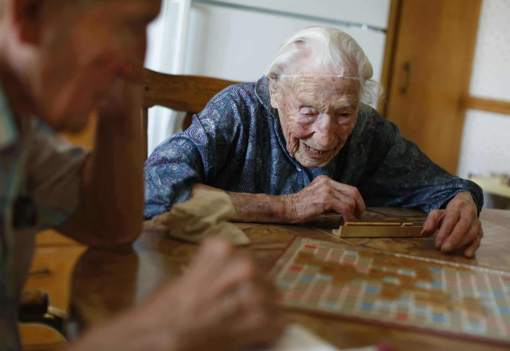 At her home in Pottsdam, Anna Stoehr,111, plays Scrabble with her son Harlan,83 who is changing the hoses on her washer. She is perhaps the oldest person who lives alone. She does not have a special diet but likes to bakes her own bread. She also likes to eat liverwurst, butter, and bacon.