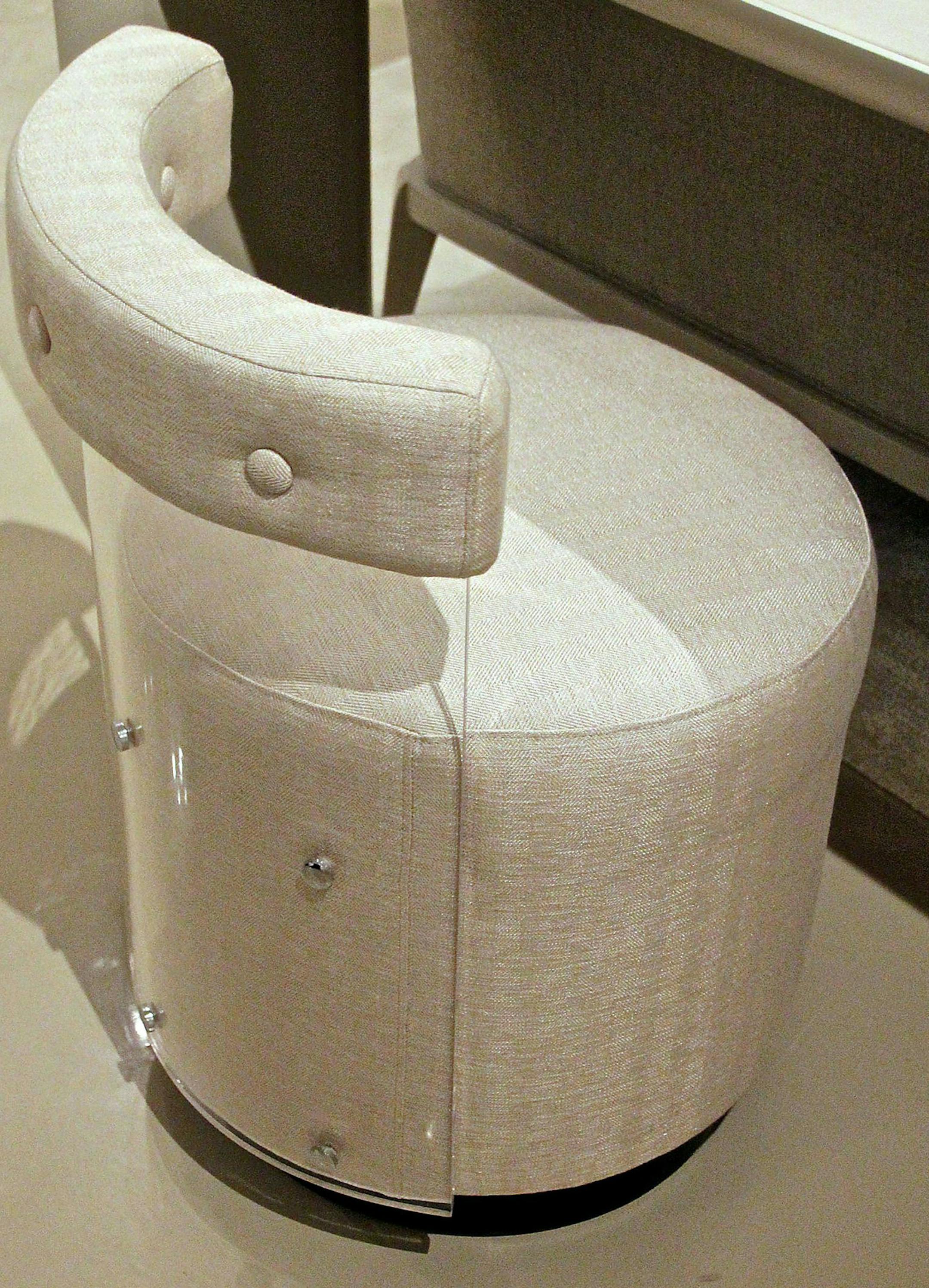 The Where's Ken? small upholstered vanity chair by Caracole combines an acrylic back with nickel accents on a wood base. (Patricia Sheridan/Pittsburgh Post-Gazette/TNS) ORG XMIT: 1187682