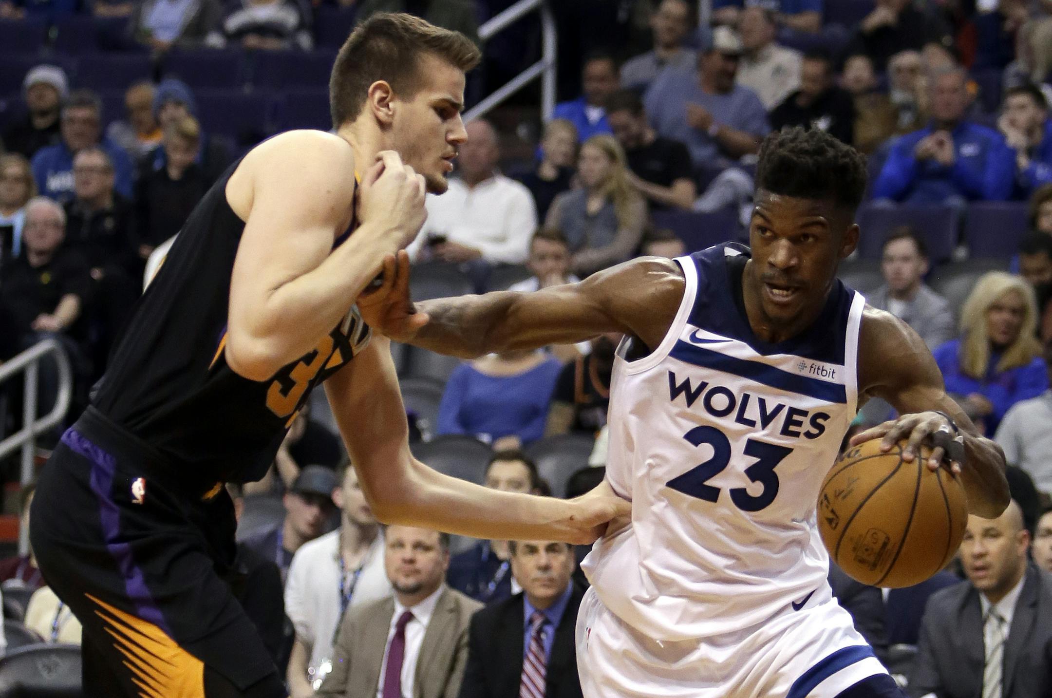 Minnesota Timberwolves guard Jimmy Butler (23) drives against Phoenix Suns forward Dragan Bender in the second quarter during an NBA basketball game, Saturday, Dec. 23, 2017, in Phoenix. (AP Photo/Rick Scuteri)