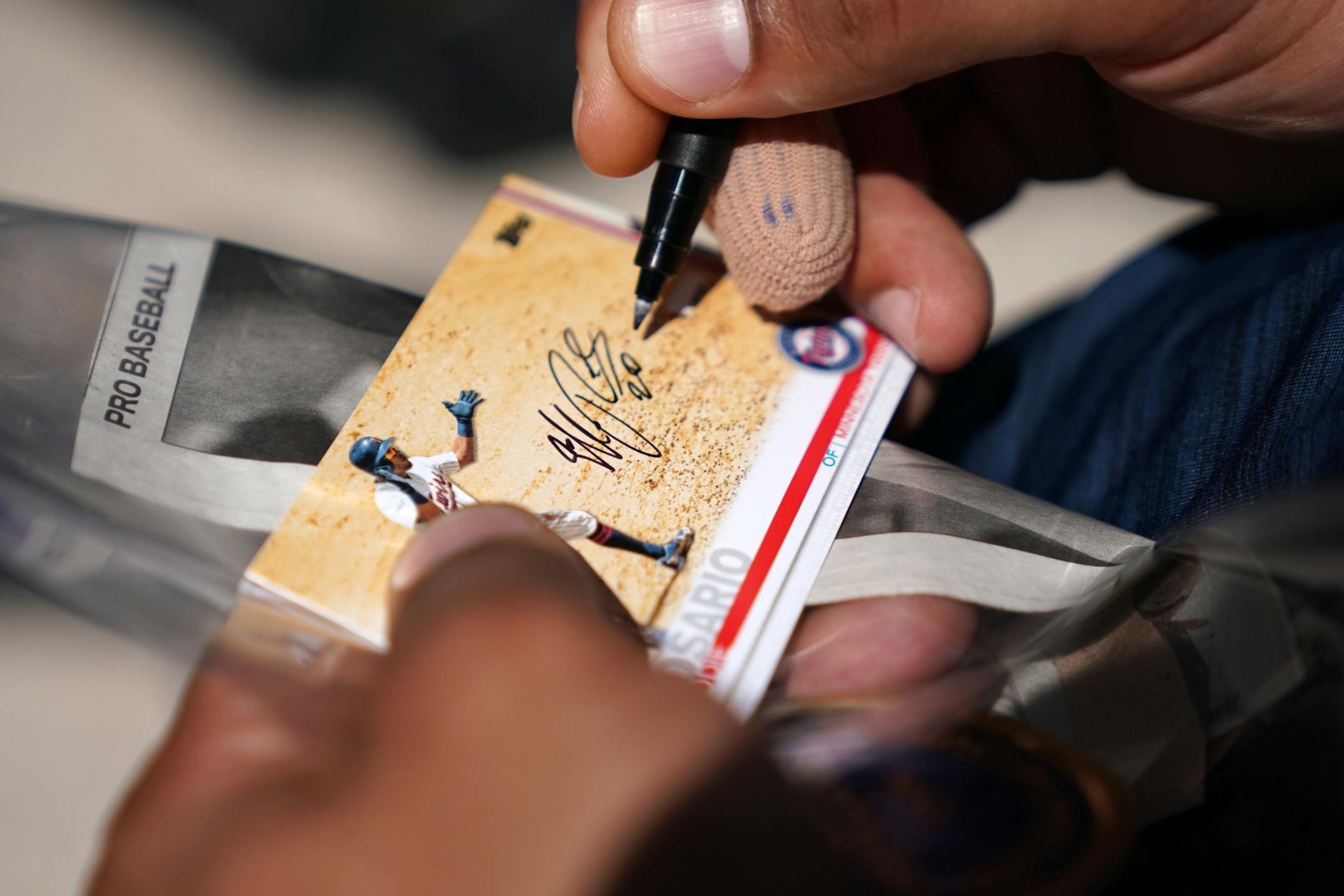 Minnesota Twins left fielder Eddie Rosario (20) signed an autograph for a fan after informal drills Saturday.