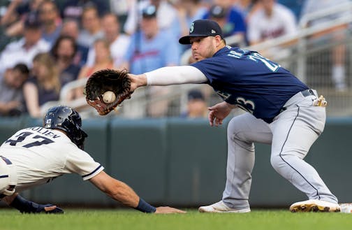 Eduardo Julian (47) of the Minnesota Twins is tagged out by Ty France (23) of the Seattle Mariners to be picked off at first base in the fourth inning.