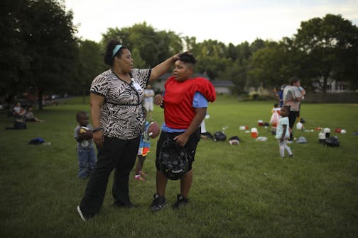 Kathryn Lusack checked in with her son, Roderick Bright, 11, when he took a water break during football practice Tuesday evening at Knob Hill Park in Burnsville.