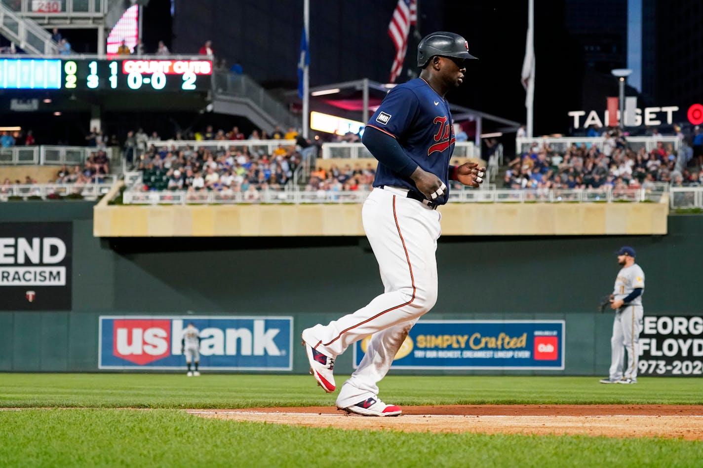 Minnesota Twins' Miguel Sano jogs home to score after Andrelton Simmons was hit by a pitch from Milwaukee Brewers' Adrian Houser with the bases loaded in the fourth inning of a baseball game Saturday, Aug. 28, 2021, in Minneapolis. (AP Photo/Jim Mone)