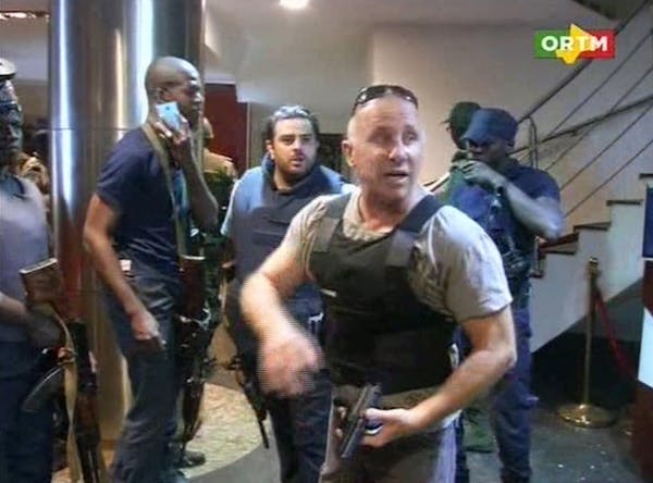 In this TV image taken from Mali TV ORTM, a security officer gives instructions to other security forces inside the Radisson Blu Hotel in Bamako, Mali