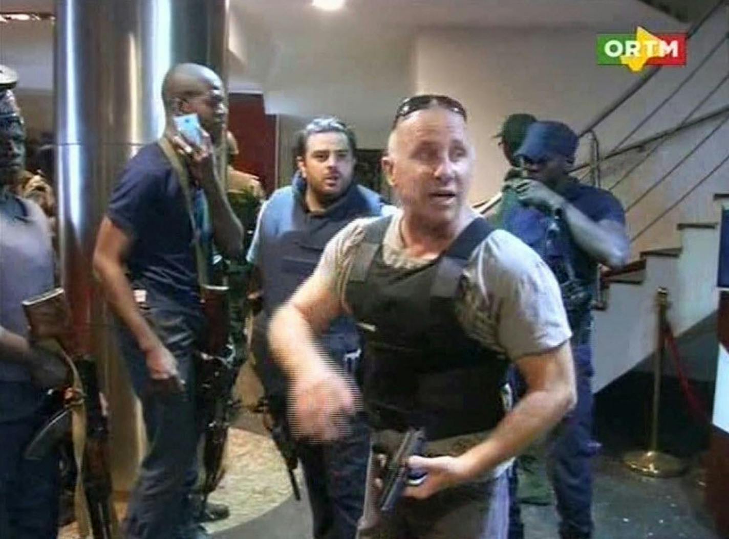 In this TV image taken from Mali TV ORTM, a security officer gives instructions to other security forces inside the Radisson Blu Hotel in Bamako, Mali, Friday Nov. 20, 2015.