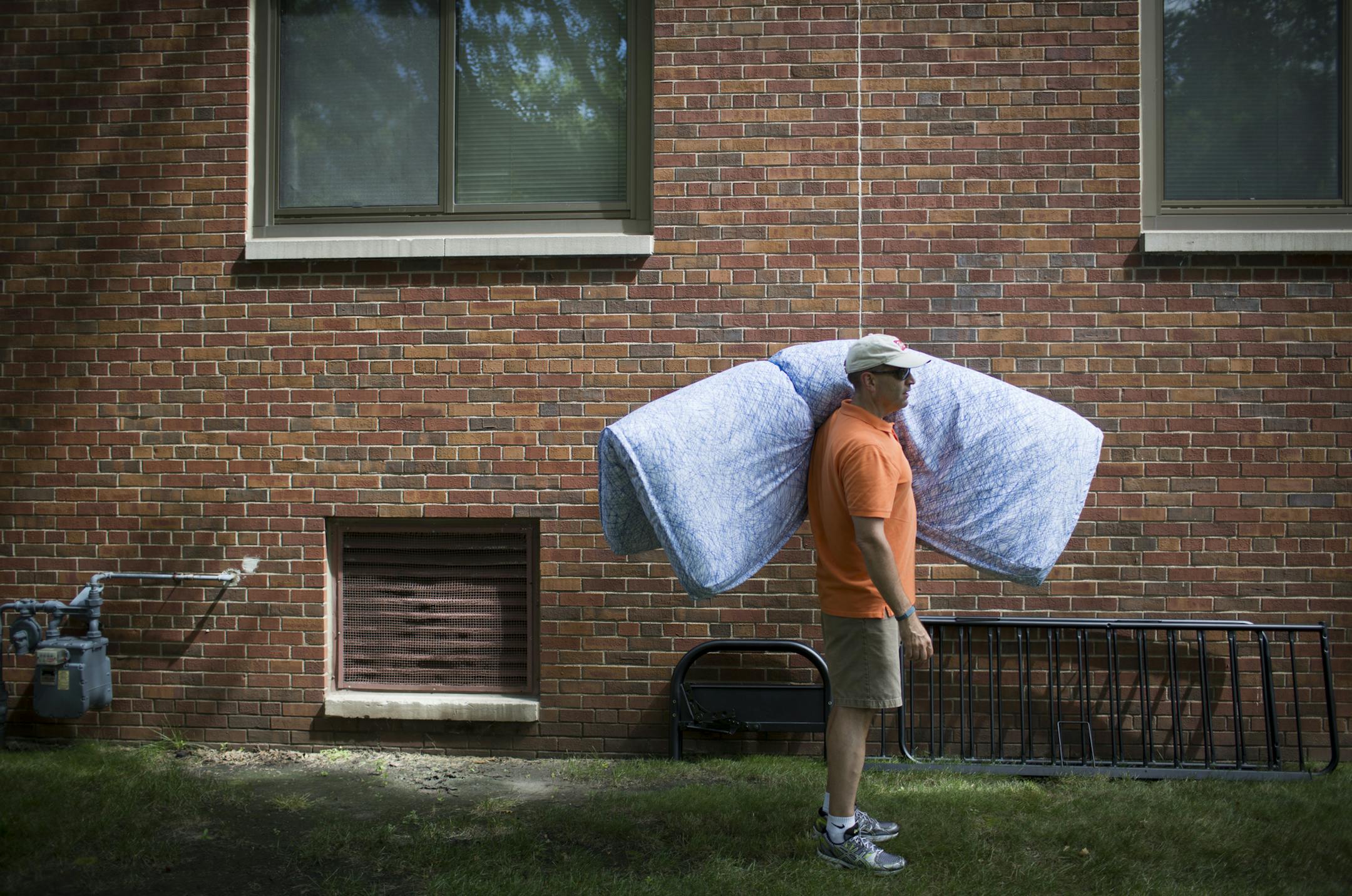 Pat Spracklin of Kenosha, Wis. held a futon mattress for his Daughter Anna as he waited to move it in to her dorm during move in day for freshman at the University of Minnesota in Minneapolis, Minn. on Monday, August 25, 2014 ] RENEE JONES SCHNEIDER • reneejones@startribune.com
