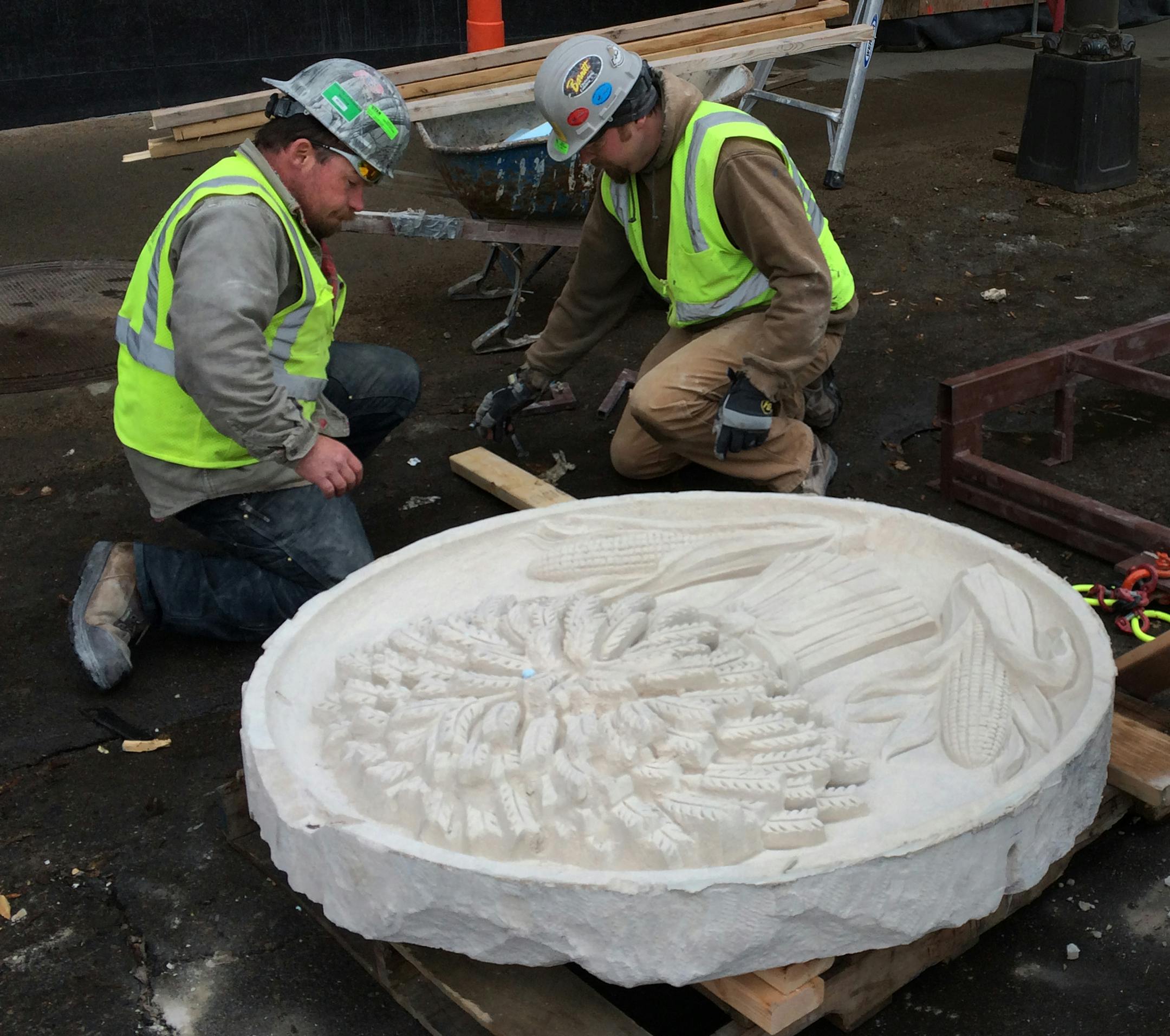 Bobby Tufts (left) and Travis Hudlow of Ryan Companies inspected the second of six historic medallions from the Star Tribune. ] MCKENNA EWEN mckenna.ewen@startribune.com - April 1, 2014, Minneapolis Star Tribune
