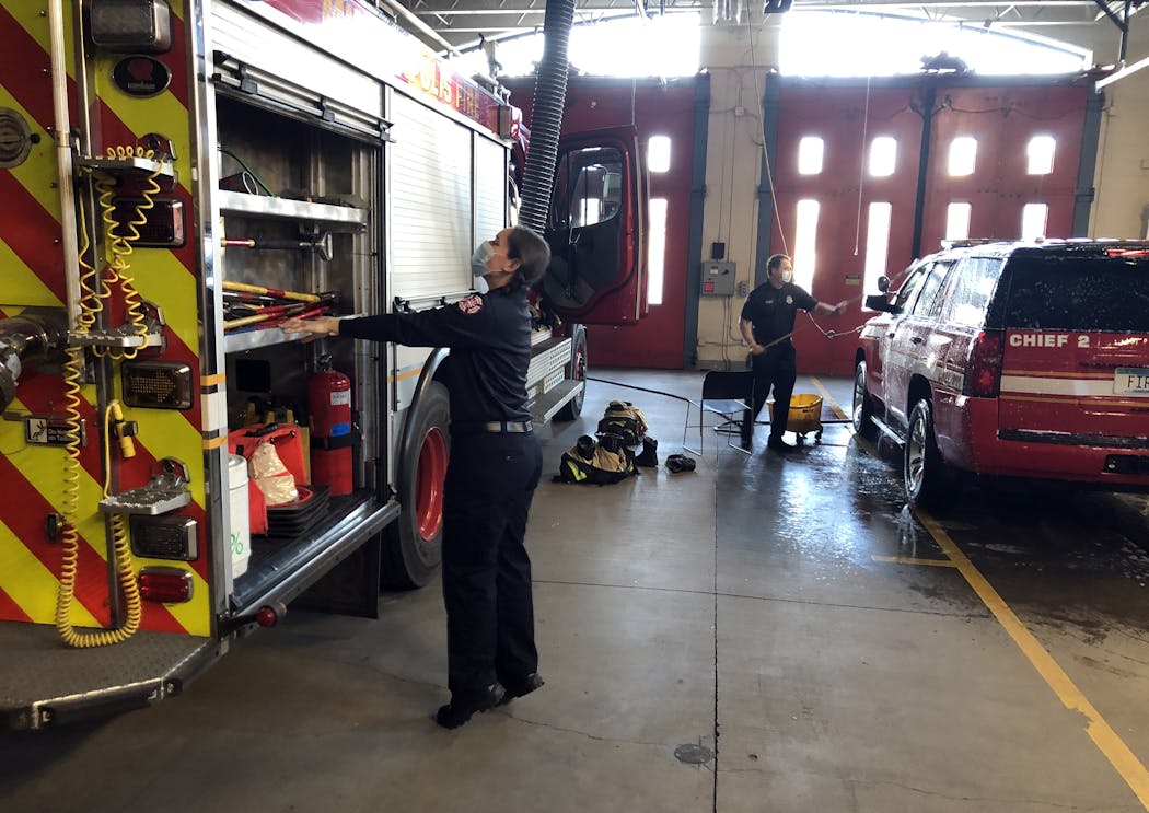 Firefighter Jenn Hall checked the rig as firefighter Steve Mudek washed the truck at Station 17 in south Minneapolis.