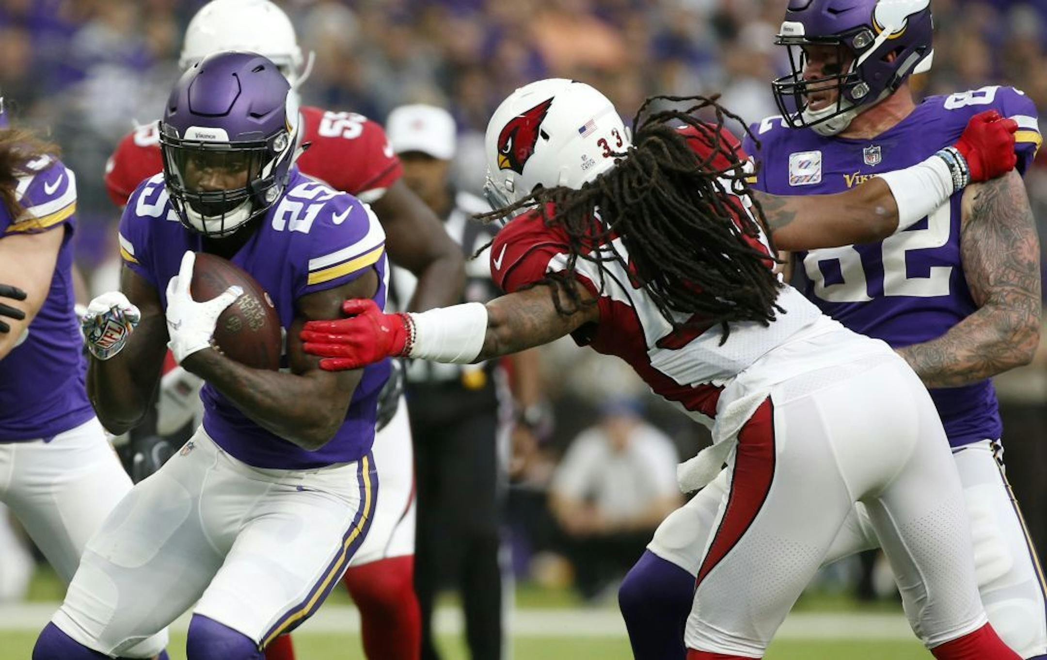 Minnesota Vikings running back Latavius Murray (25) breaks a tackle by Arizona Cardinals defensive back Tre Boston, right, during a 21-yard touchdown run in the first half of an NFL football game, Sunday, Oct. 14, 2018, in Minneapolis.