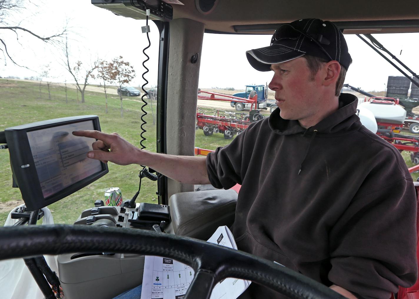 Farmer Craig Breuer programmed the GPS control unit on a Case STX 325 tractor before planting corn on fields.