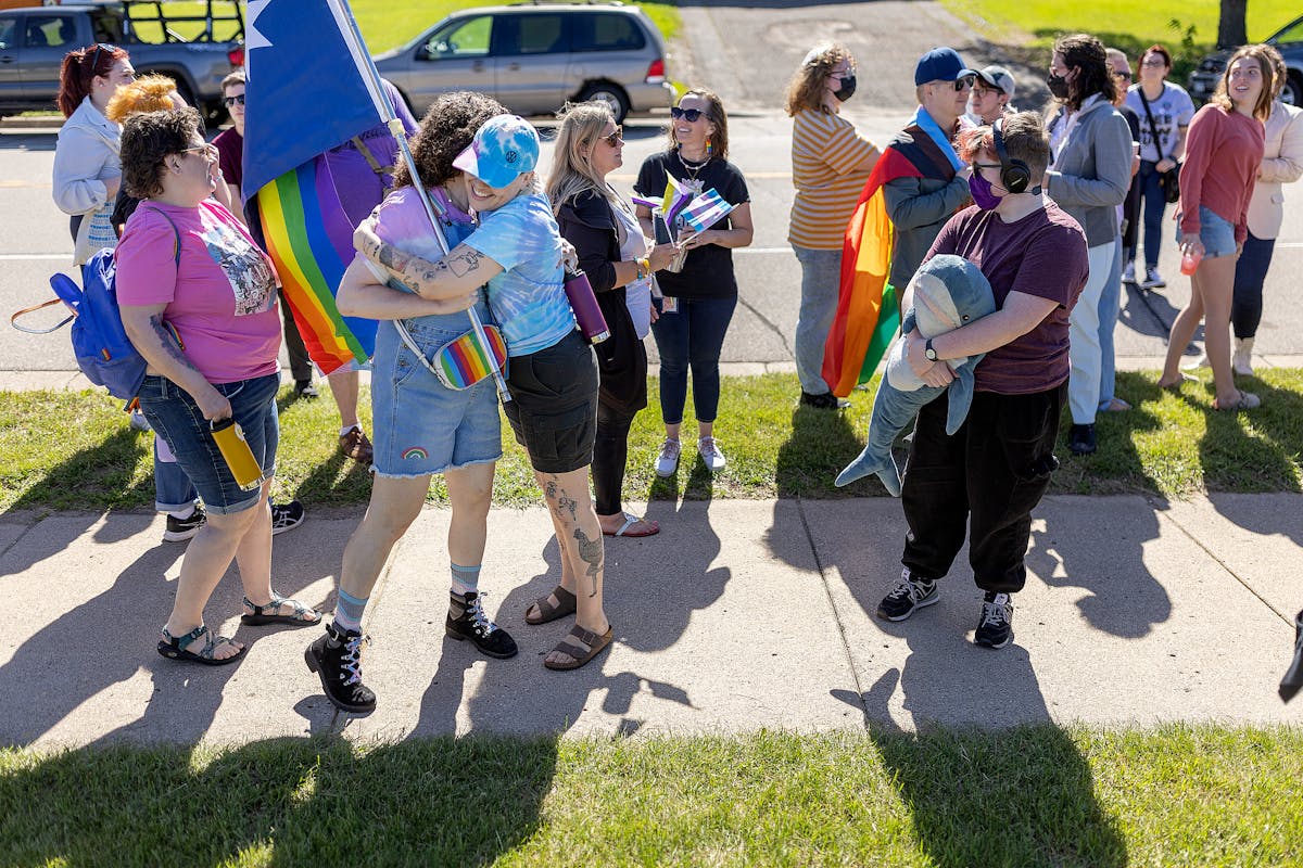 Myrtle Lemon-Todd, center in blue, gives hugs to others as they rally in support of a transgender student who allegedly was attacked leaving a bathroo