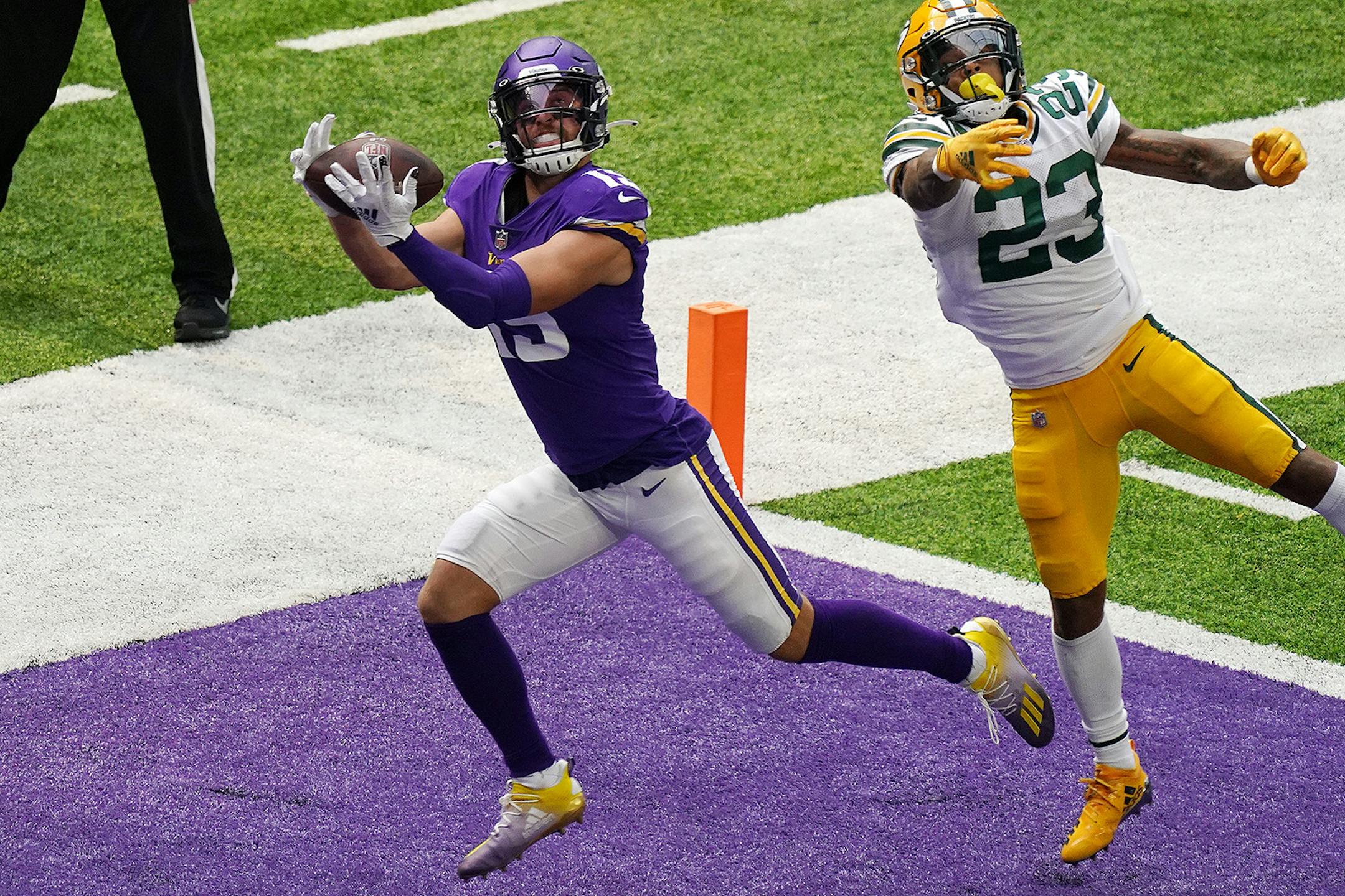 Minnesota Vikings wide receiver Adam Thielen (19) hauled in a touchdown pass from quarterback Kirk Cousins (8) as Green Bay Packers cornerback Jaire Alexander (23) tried to defend in the fourth quarter.