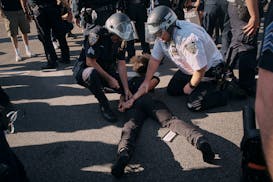 Police detain a pro-Palestinian demonstrator in front of the Brooklyn Museum during a protest demanding a permanent cease-fire in Gaza on Friday, May 