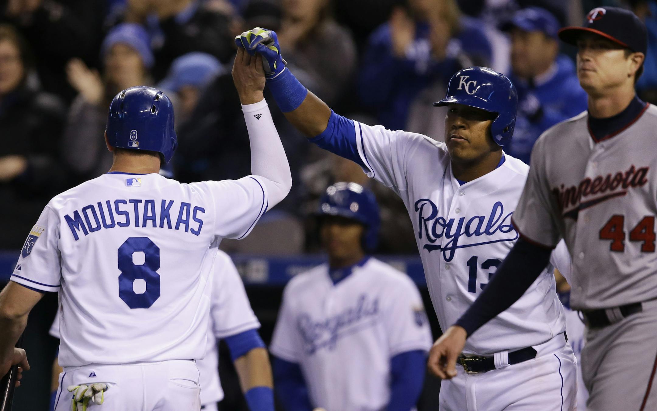 Royals third baseman Mike Moustakas celebrated with teammate Salvador Perez (13) after scoring during the sixth inning in a 7-1 romp over the Twins at Kauffman Stadium on Monday. Twins starter Kyle Gibson returned to the mound after the play.