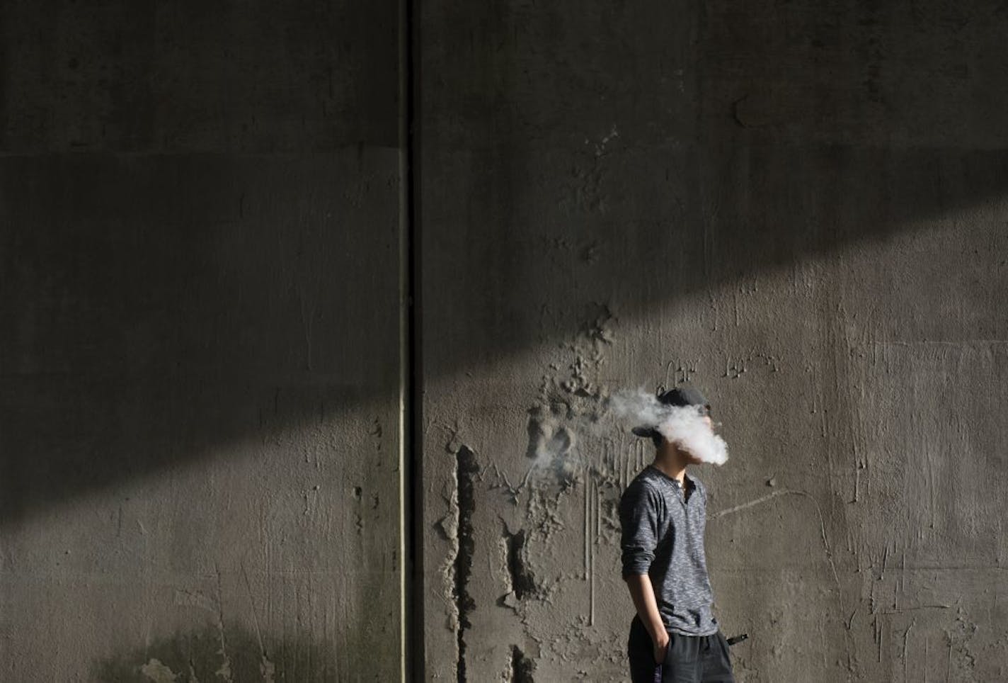 FILE -- A 15-year-old boy vapes in Peekskill, N.Y., April 16, 2015. A national panel of public health experts concluded in a report released on Jan. 23, 2018, that vaping with e-cigarettes that contain nicotine can be addictive and that teenagers who use the devices may be put at higher risk of switching to traditional smoking.