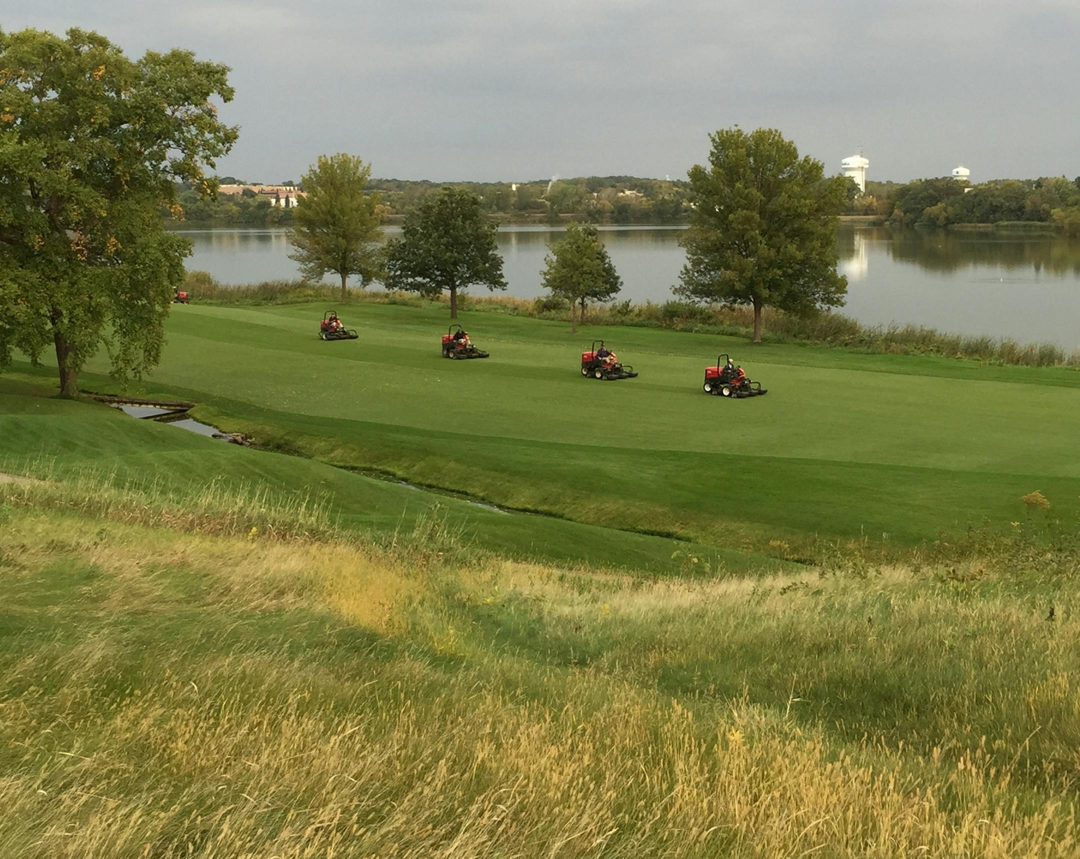 Toro mowers on Hazeltine's 16th fairway with Lake Hazeltine in the background. Course preparation for the 2016 Ryder Cup began soon after the club finished hosting the 2009 PGA Championship last fall.