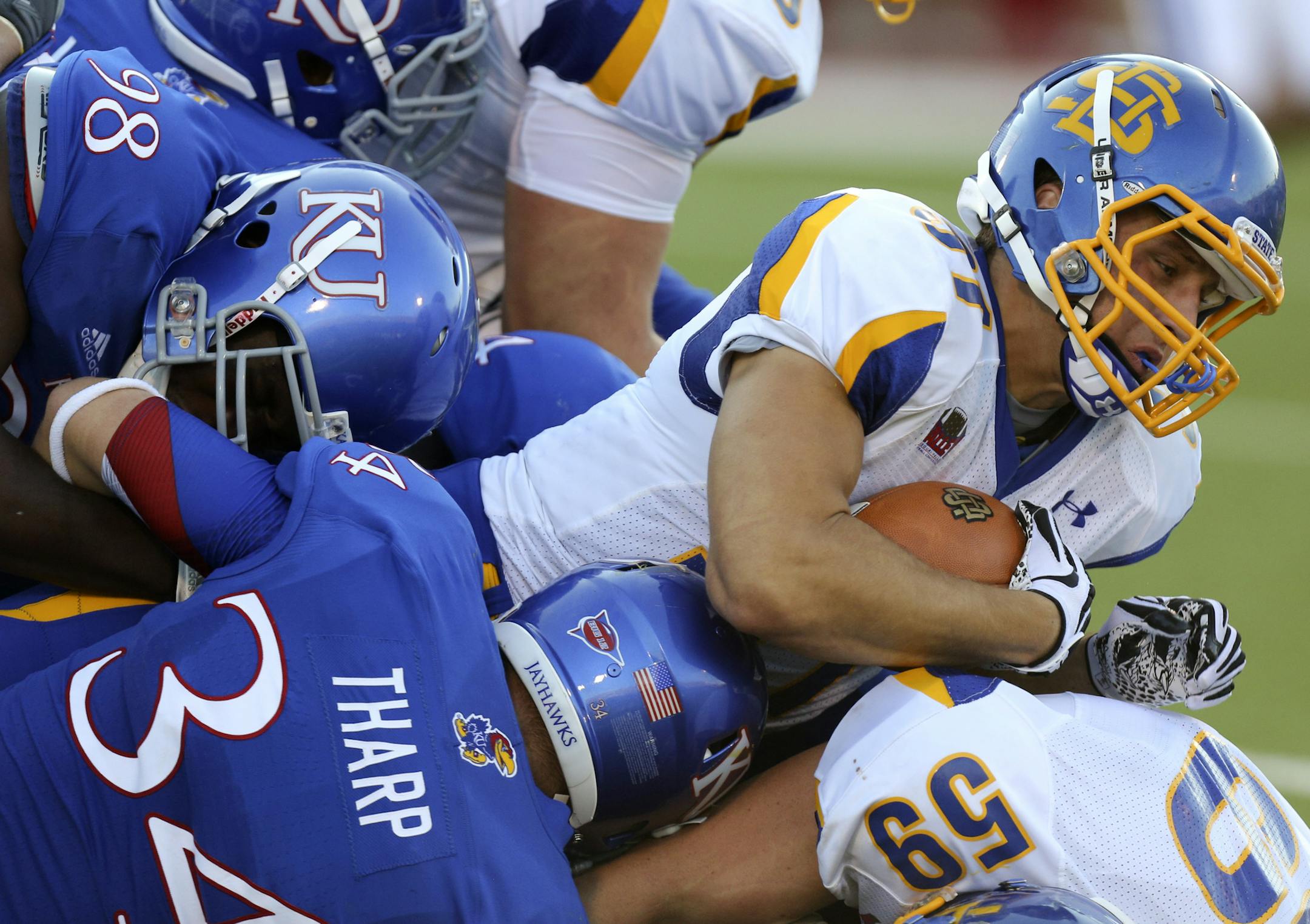 South Dakota State running back Zach Zenner dives between Kansas' Keon Stowers (98) and Huldon Tharp as he picks up four yards in the second quarter of an NCAA college football game Saturday, Sept. 1, 2012, in Lawrence, Kan. (AP Photo/Ed Zurga) ORG XMIT: KSEZ108