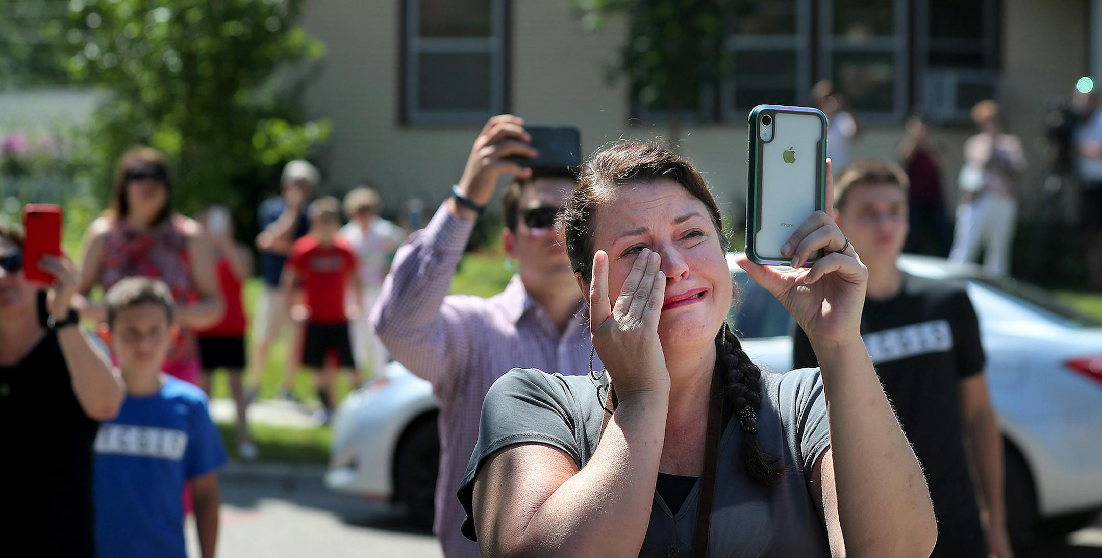 Demolition of the former St. Andrew's Church in Como Park began Tuesday, Aug. 13, 2019, in St. Paul, MN. Here, Kristi Donahue, a neighbor to the church, got emotional while photographing the scene. "This building was the heart of our neighborhood."] DAVID JOLES • david.joles@startribune.com Demolition of the former St. Andrew's Church in Como Park -- as dozens of unhappy neighbors and preservationists look on.