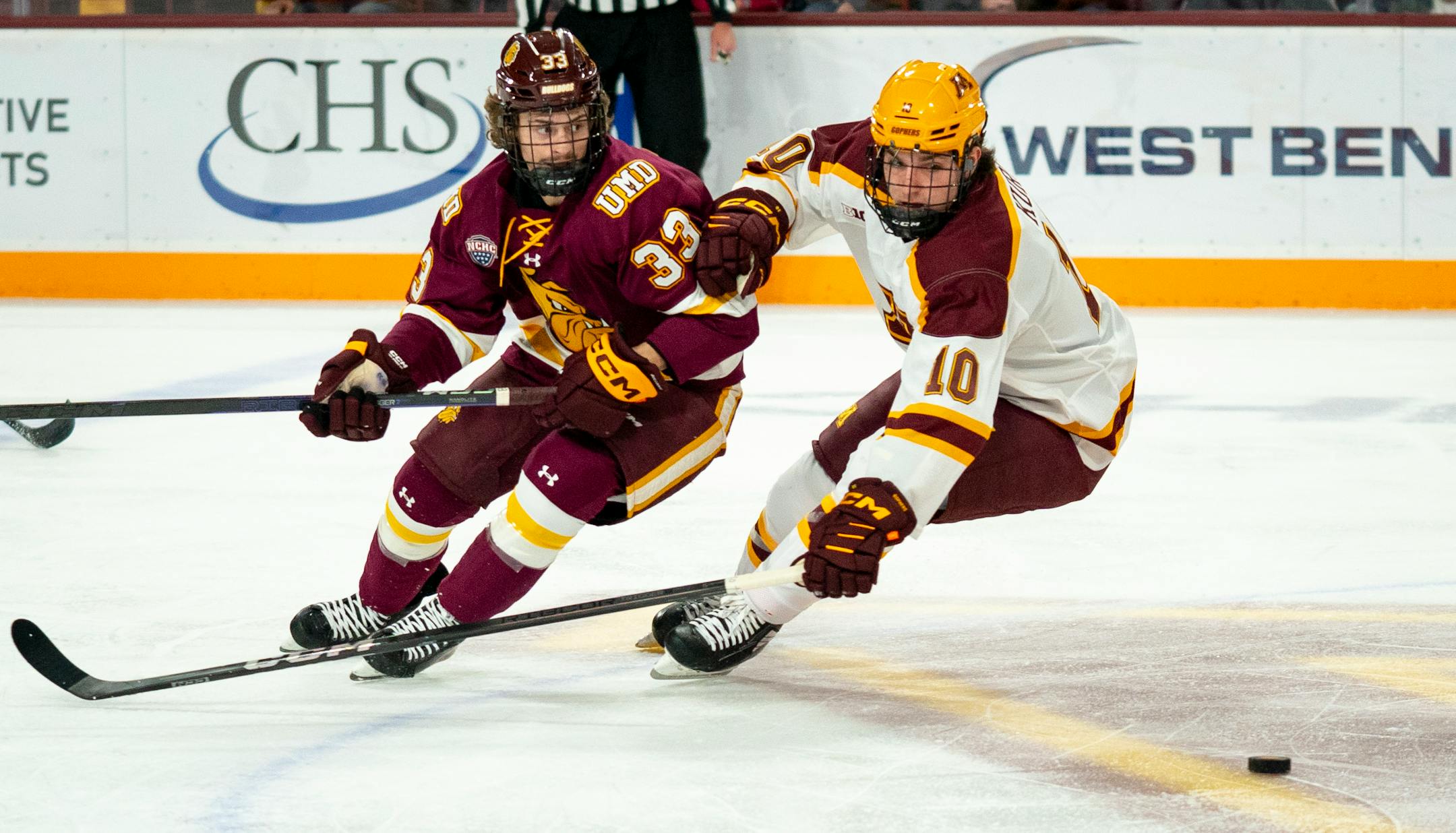 Minnesota forward Connor Kurth (10) and Duluth Center Carter Loney race for the puck.