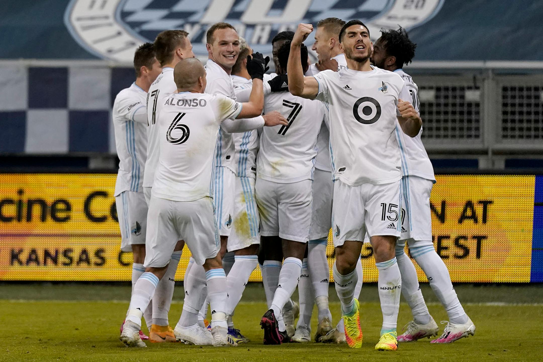 Minnesota United players celebrate after a goal by Bakaye Dibassy during the first half of an MLS soccer match against Sporting Kansas City Thursday, Dec. 3, 2020, Kansas City, Kan. (AP Photo/Charlie Riedel)