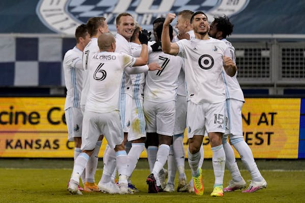 Minnesota United players celebrate after a goal by Bakaye Dibassy during the first half of an MLS soccer match against Sporting Kansas City Thursday, 
