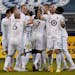 Minnesota United players celebrate after a goal by Bakaye Dibassy during the first half of an MLS soccer match against Sporting Kansas City Thursday, 