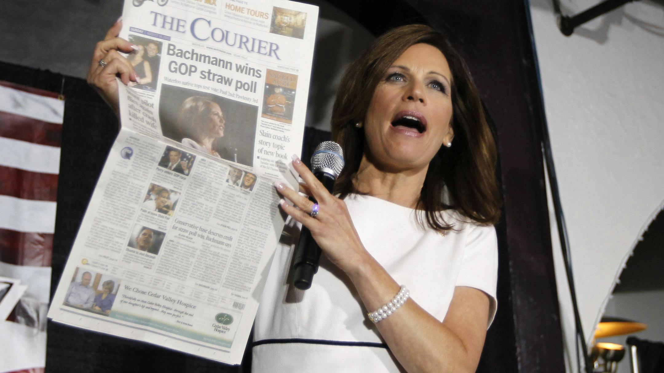 Addressing the Black Hawk County Republican Party Lincoln Day Dinner in Waterloo on Sunday, presidential candidate Michele Bachmann held up a newspaper displaying results of the GOP Straw Poll.