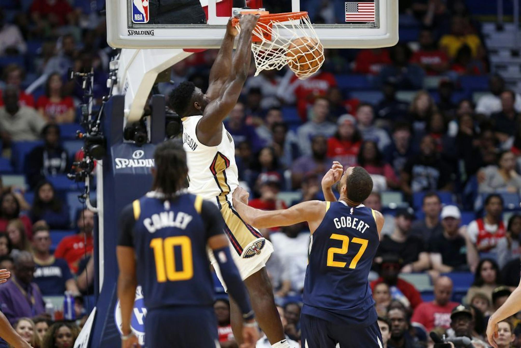 New Orleans Pelicans forward Zion Williamson (1) dunks over Utah Jazz center Rudy Gobert (27) during the second half of a preseason NBA basketball game in New Orleans, Friday, Oct. 11, 2019.